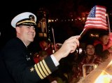 NAS Lemoore Commander, Capt. Shawn O'Connor waves a flag during annualh Veterans Day Parade.